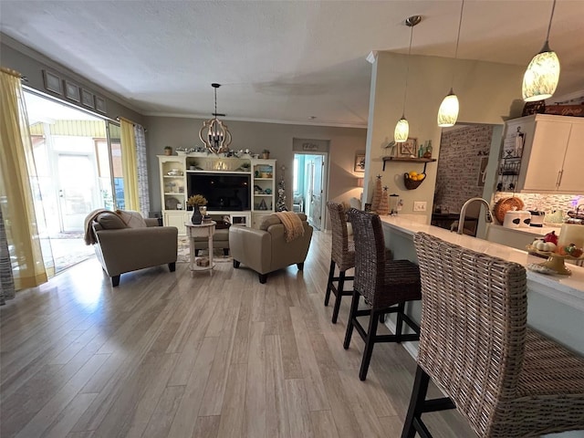 interior space with an inviting chandelier, light hardwood / wood-style flooring, and ornamental molding