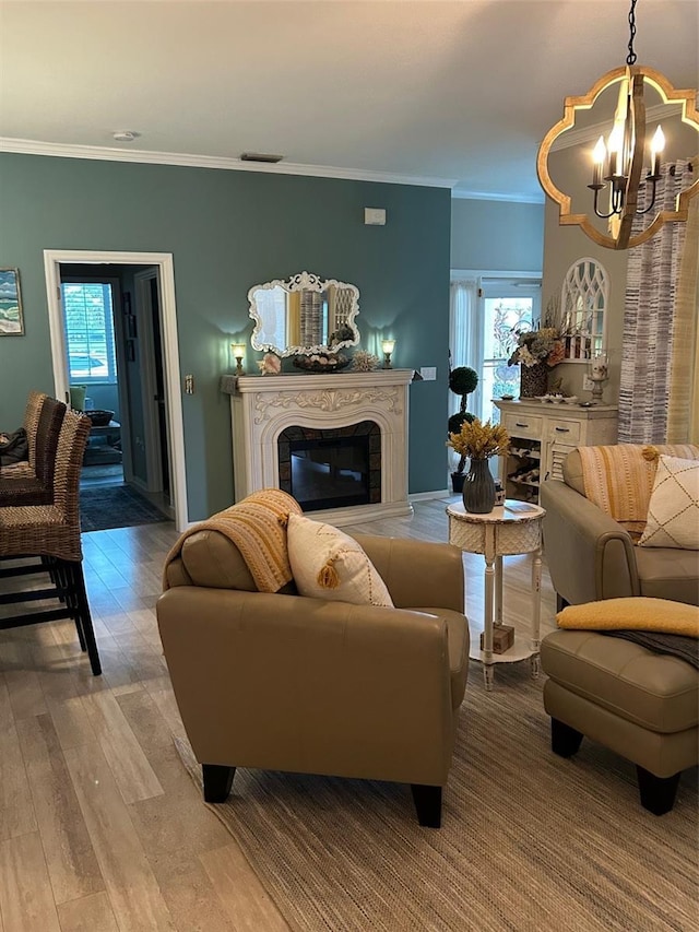 living area featuring plenty of natural light, a fireplace, wood finished floors, and visible vents