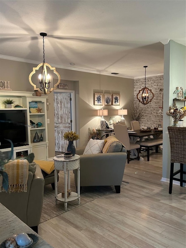 living room with light wood-type flooring, an inviting chandelier, and crown molding