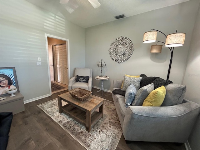 living room featuring a ceiling fan, baseboards, visible vents, and wood finished floors