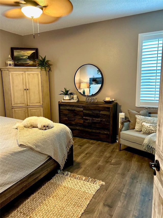 bedroom with ceiling fan and dark wood-type flooring