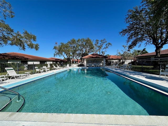 pool with fence and a patio