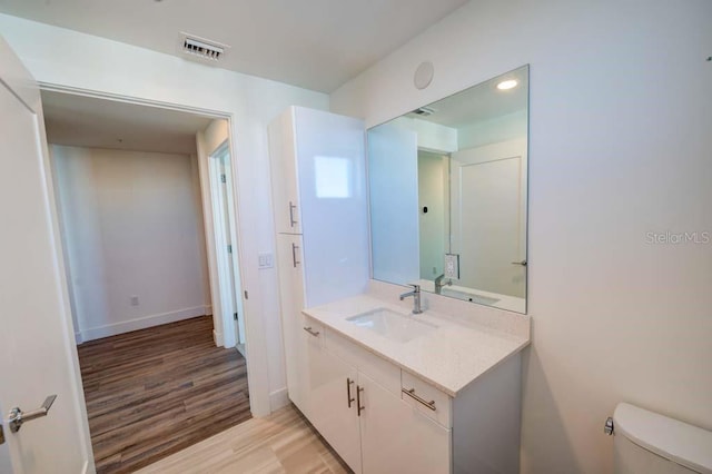 bathroom featuring vanity, toilet, and wood-type flooring