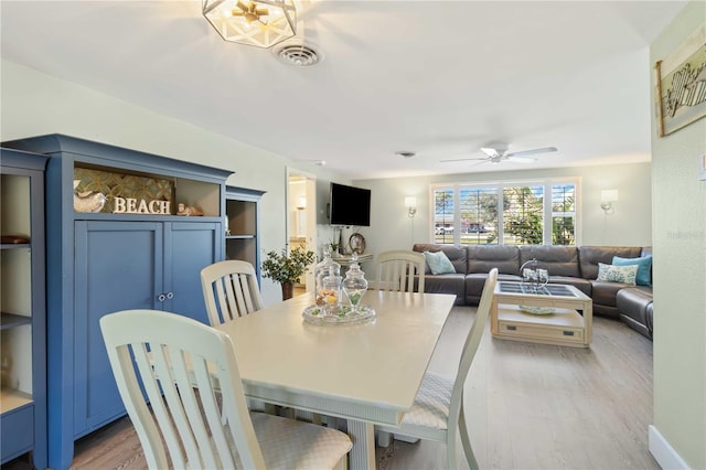 dining area with ceiling fan and light hardwood / wood-style floors