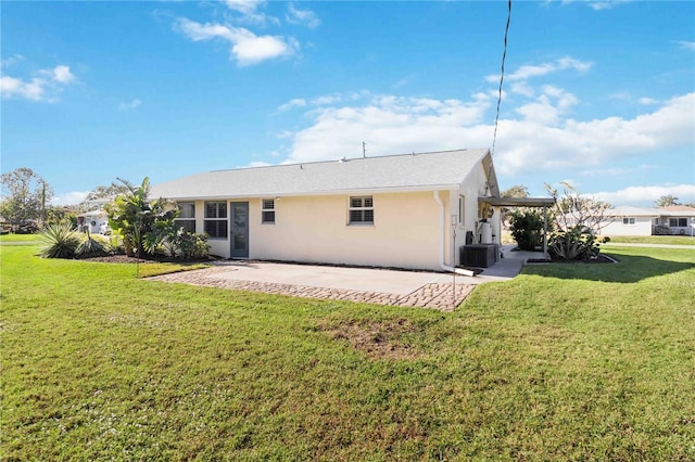 rear view of house with cooling unit, a yard, and a patio