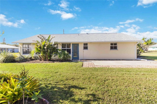 rear view of property featuring a lawn and a patio