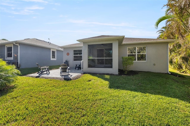 rear view of property featuring a patio, a sunroom, and a lawn