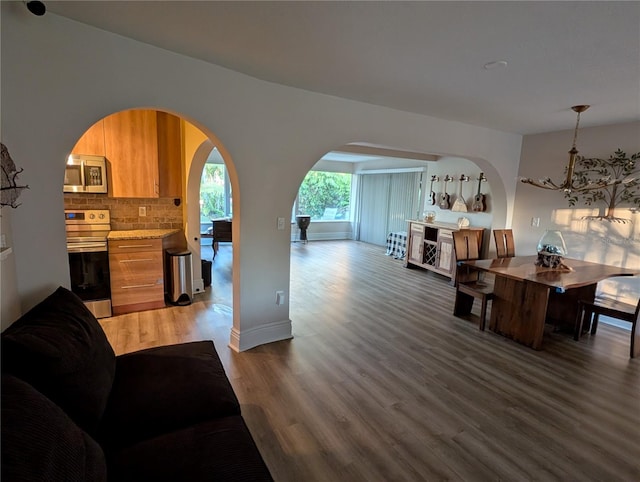 living room with a chandelier and dark wood-type flooring