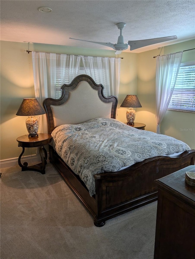 carpeted bedroom with a textured ceiling and ceiling fan