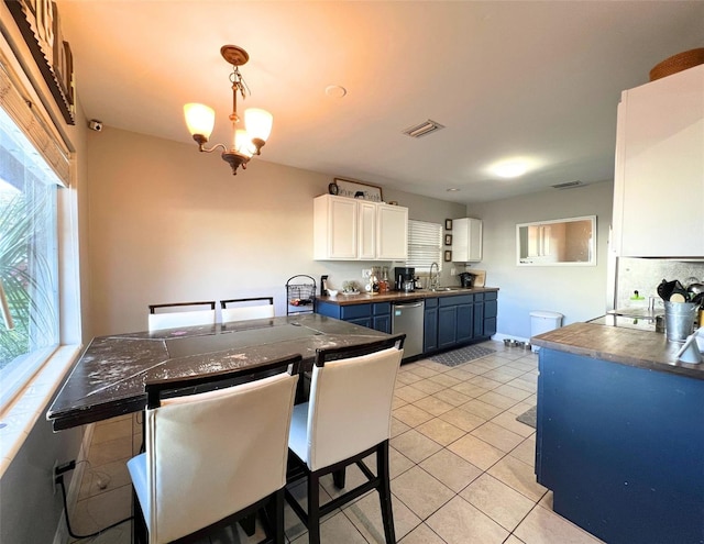 kitchen with sink, an inviting chandelier, a kitchen breakfast bar, blue cabinets, and white cabinets