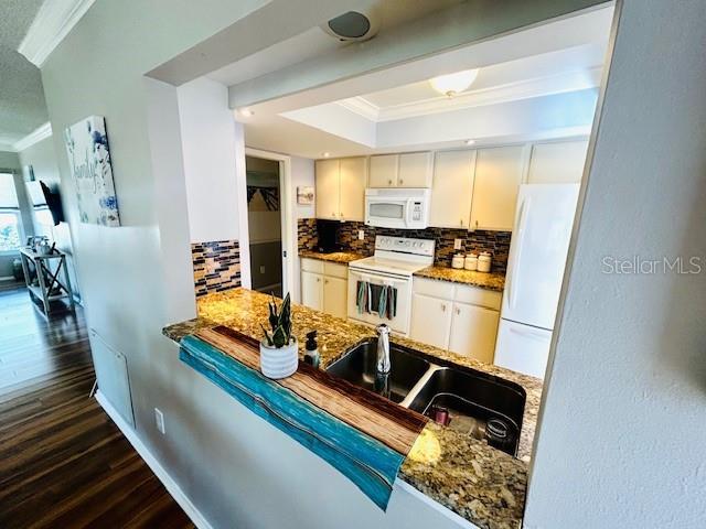 kitchen featuring ornamental molding, sink, white cabinets, and white appliances