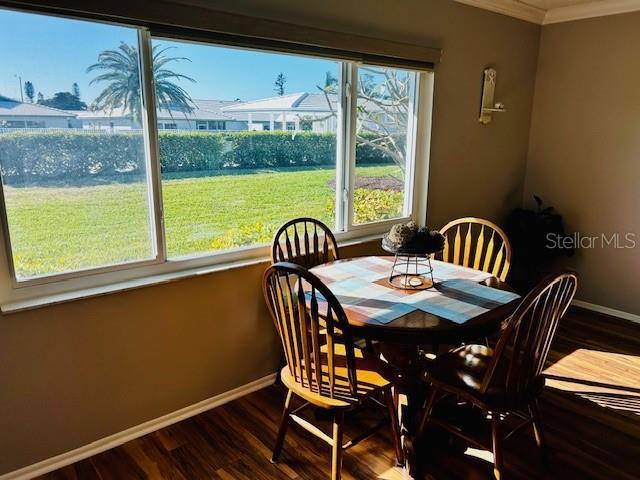 dining space with crown molding, a healthy amount of sunlight, and hardwood / wood-style floors