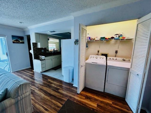 laundry area featuring washer and clothes dryer, dark hardwood / wood-style floors, and a textured ceiling