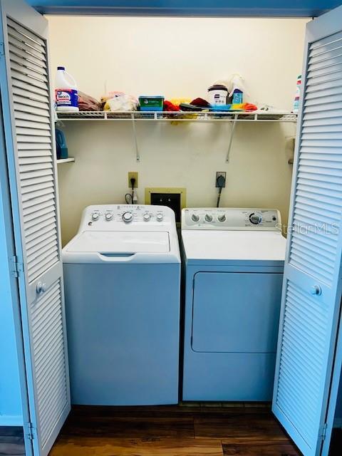 washroom featuring dark hardwood / wood-style flooring and washing machine and clothes dryer