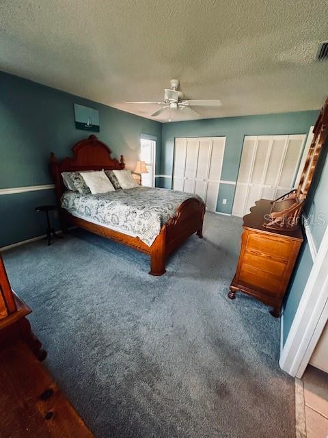 bedroom featuring carpet flooring, a textured ceiling, and ceiling fan