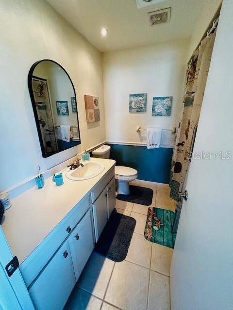 bathroom featuring tile patterned flooring, vanity, and toilet