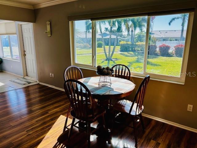 dining area with crown molding and dark hardwood / wood-style floors