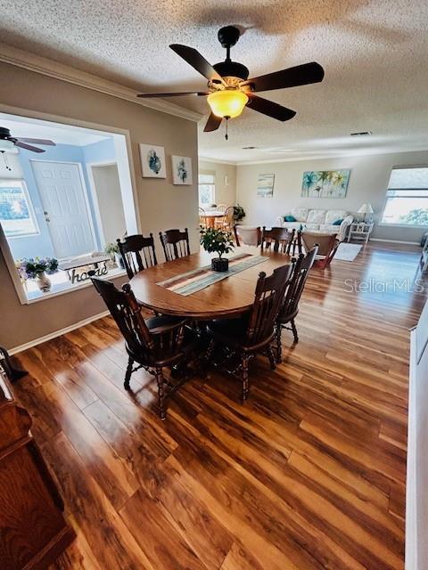 dining space with hardwood / wood-style flooring, ceiling fan, and a textured ceiling