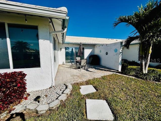 back of property featuring a yard and a patio