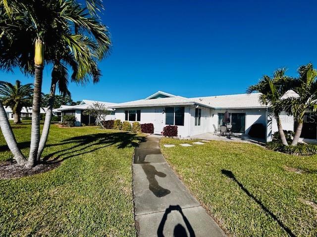 ranch-style house with a patio area and a front lawn