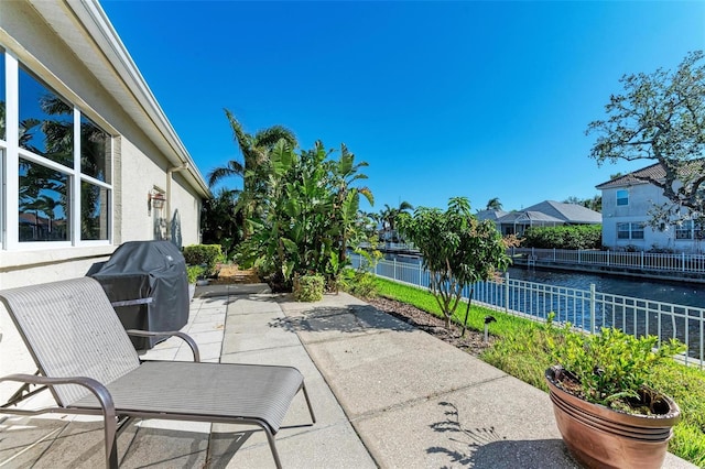 view of patio featuring a grill and a water view