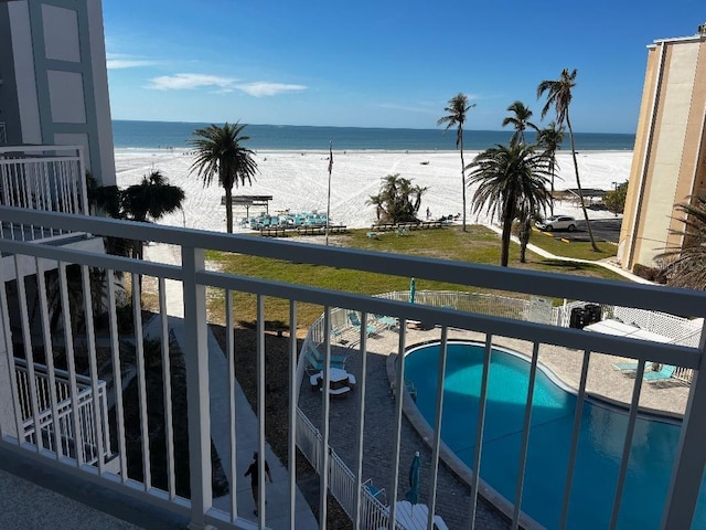 balcony with a water view and a view of the beach