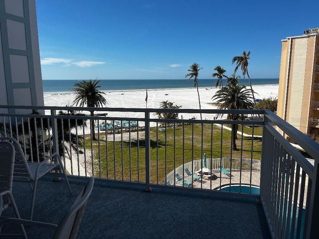 balcony featuring a water view and a view of the beach