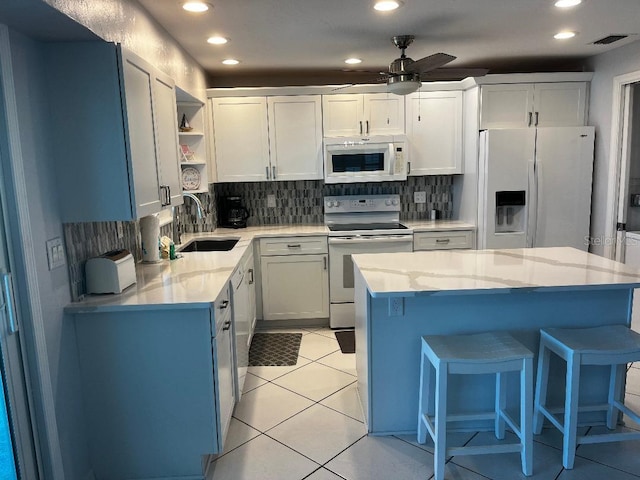 kitchen with white cabinetry, white appliances, and sink