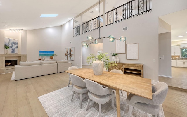 dining room with a towering ceiling and light hardwood / wood-style floors