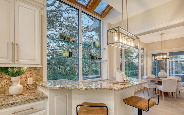 kitchen featuring pendant lighting, light hardwood / wood-style flooring, and a wealth of natural light