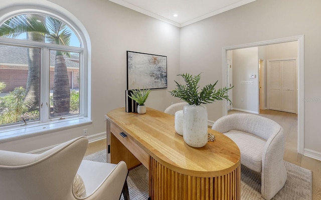 home office with crown molding and light hardwood / wood-style flooring