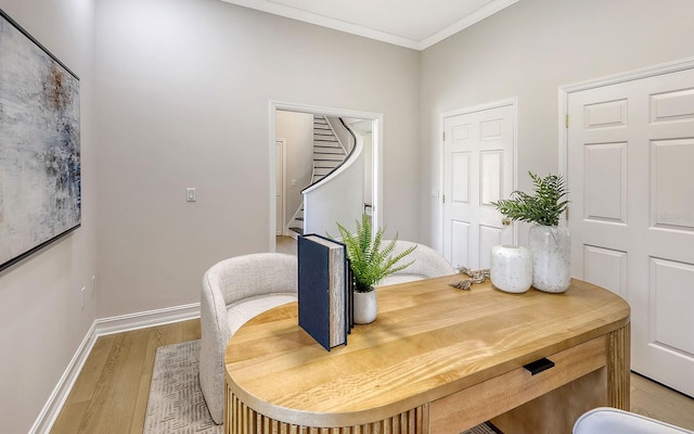 dining space featuring light wood-type flooring and ornamental molding