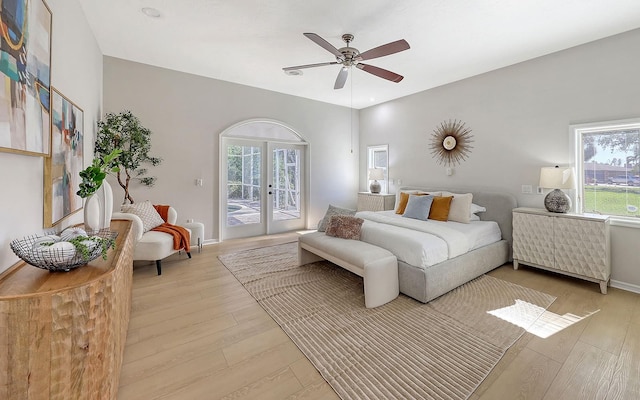 bedroom with access to exterior, light hardwood / wood-style floors, and multiple windows