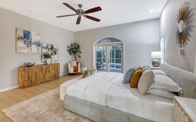 bedroom with access to exterior, french doors, light wood-type flooring, and ceiling fan