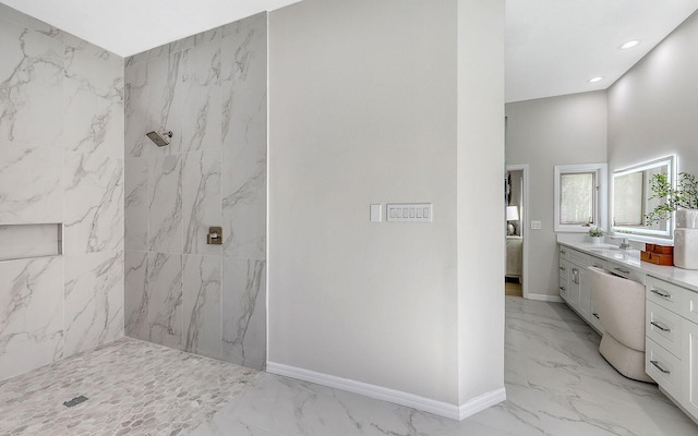 bathroom with tiled shower and vanity