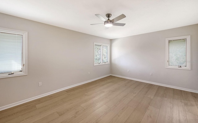 empty room with ceiling fan and light hardwood / wood-style floors