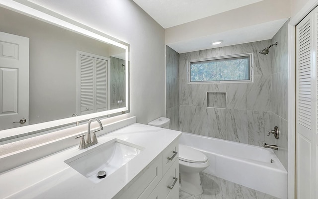 full bathroom featuring tiled shower / bath, vanity, and toilet