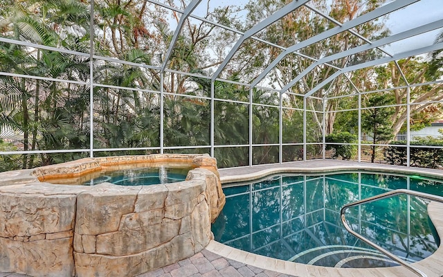 view of pool featuring glass enclosure and an in ground hot tub