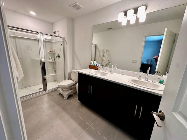 bathroom with tile patterned flooring, vanity, toilet, and a shower with shower door