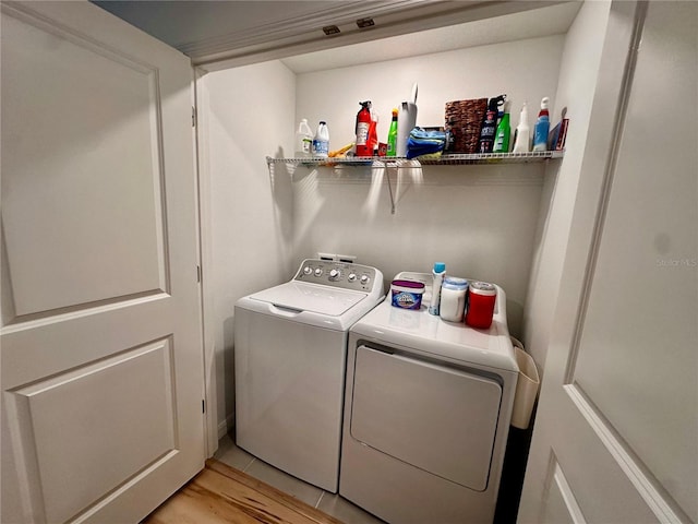 clothes washing area featuring light tile patterned flooring and washing machine and clothes dryer