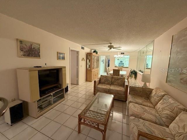 living room with ceiling fan, light tile patterned floors, and a textured ceiling