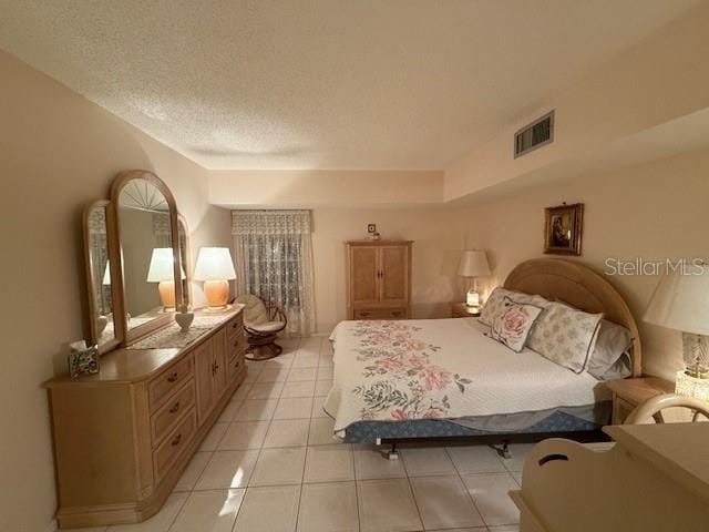 bedroom with light tile patterned floors and a textured ceiling