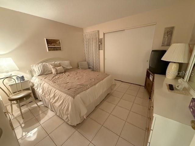 tiled bedroom with a closet