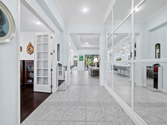 hallway with french doors, light wood-type flooring, and ornamental molding