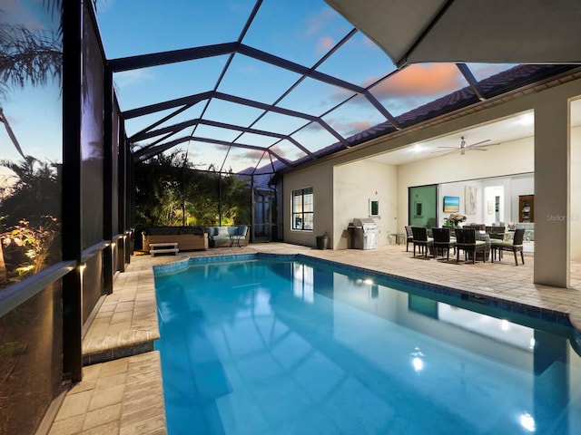 pool at dusk featuring ceiling fan, a patio area, a lanai, and a hot tub