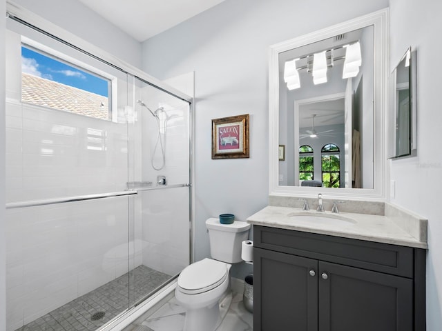 bathroom with vanity, toilet, and a shower with door