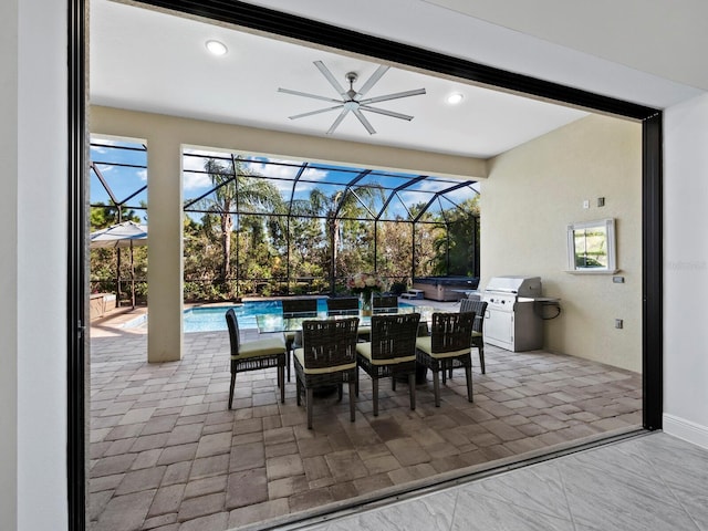 view of patio with a lanai, area for grilling, ceiling fan, and a swimming pool with hot tub