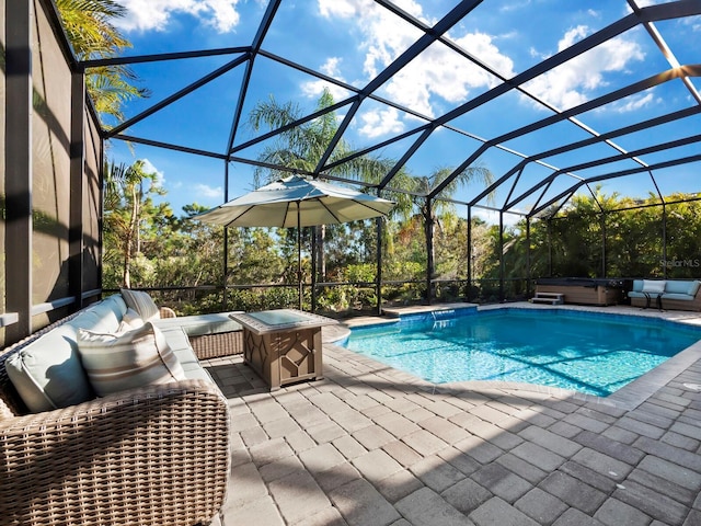 view of swimming pool featuring glass enclosure, a patio area, and a hot tub