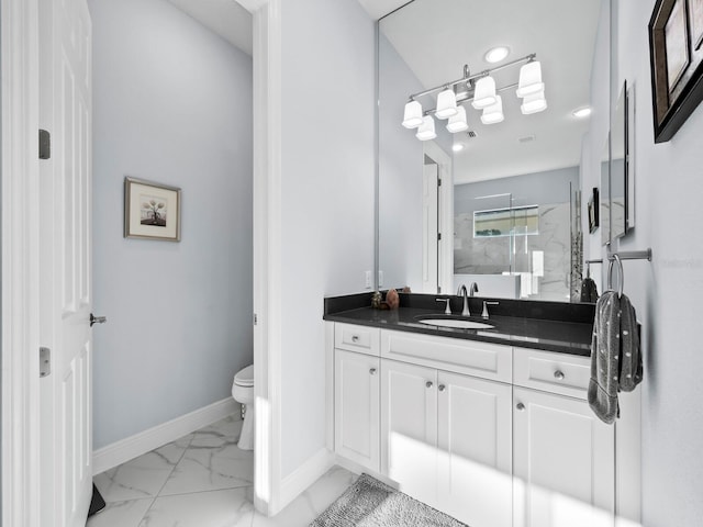 bathroom featuring vanity, a shower with shower door, and toilet