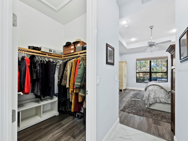 walk in closet with hardwood / wood-style flooring and ceiling fan